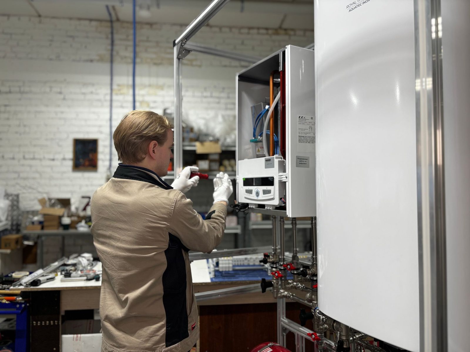 Engineer assembling a new wall-hung boiler on a test rig